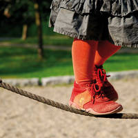 Kind balanciert über Seil auf dem Kindergarten-Spielplatz Kind balanciert über Seil auf dem Kindergarten-Spielplatz